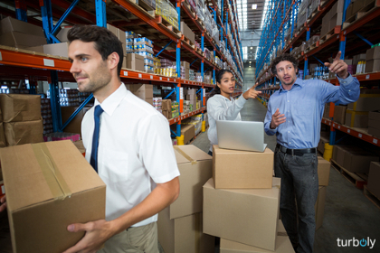 Workers talking and pointing shelves in a warehouse