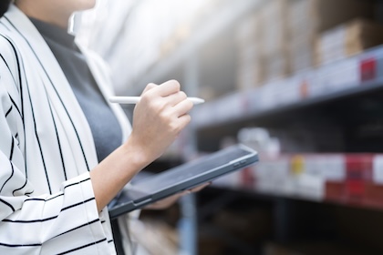 Close up female business owner hand hold tablet device checking inventory stock at shop warehouse distributor factory business ideas concept